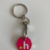 Silver trolley keyring with .h on the front with a pink background