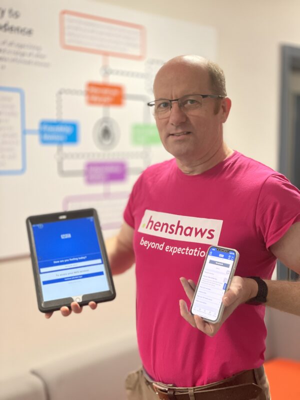 Richard with a mobile and tablet with the NHS app uploaded