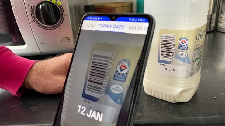 Audible app open on a phone scanning a pint of milk