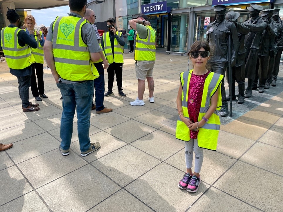 The Project Team and a Henshaws volunteer outside Manchester Piccadilly Train Station, wearing Sight Loss simulation glasses and Hi-Viz jackets Getting ready for their Visual Impairment Awareness Training.