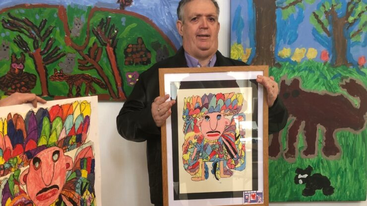 Andrew holding his colourful painting 'The Pearly King'